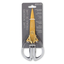 Load image into Gallery viewer, Gold and silver scissors in packaging with dobalt branding on a white background