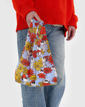 Load image into Gallery viewer, a person holding a baggu brand reusable bag in a snoopy peanuts cartoon pattern with flowers