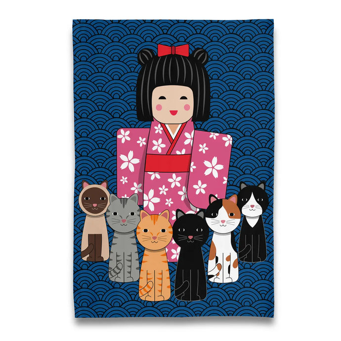 a tea towel with Japanese styled doll and six little kitties on a blue background 