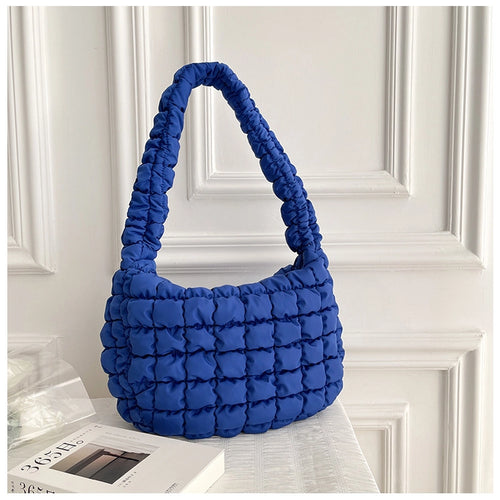 a phot of a colbalt blue coloured handbag made with a puffy quilted look 