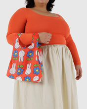 Load image into Gallery viewer, a person holding a baggu brand reusable bag with a miffy motif