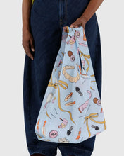 Load image into Gallery viewer, a person holding a baggu reusable bag with the get ready with me motif
