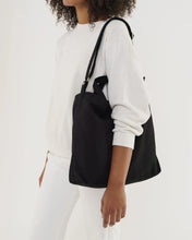 Load image into Gallery viewer, a person holding a black baggu canvas duck bag 
