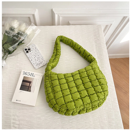 A photo of a green coloured handbag with a quilted puffy look to it 
