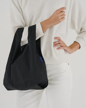 Load image into Gallery viewer, a person holding the baggu reusable baby sized bag in a solid black colour