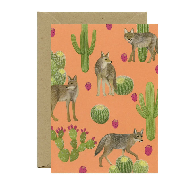 a greeting card with illustration of several coyotes amidst cactus on peach coloured background. no txt