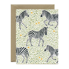 Load image into Gallery viewer, a greeting card with illustration of several zebras on little green blades of grass and leaves , no text