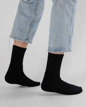 Load image into Gallery viewer, a person wearing jeans and a pair of black baggu socks 
