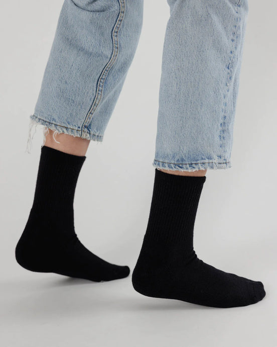 a person wearing jeans and a pair of black baggu socks 