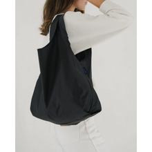 Load image into Gallery viewer, a person holding a baggu reusable bag in a solid black colour