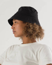 Load image into Gallery viewer, a person wearing a black baggu bucket hat 
