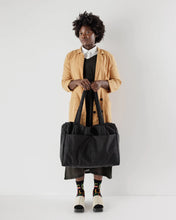 Load image into Gallery viewer, a person holding a large black tote bag made by baggu
