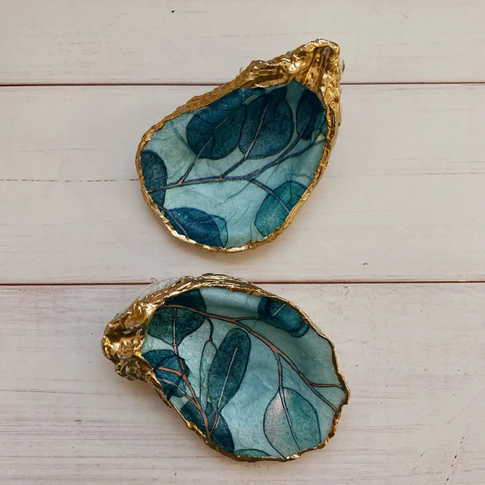 2 oyster shells with greenish blues eucalyptus painted inside with gold painted trim on edges 