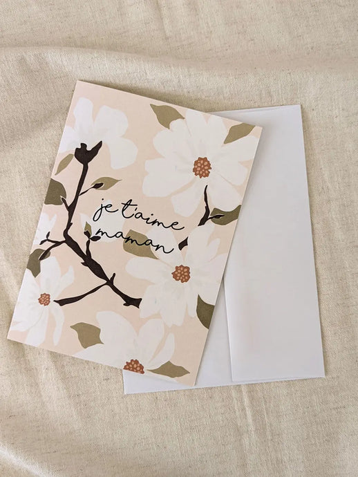 a greeting card with white flowers text je t'aime maman