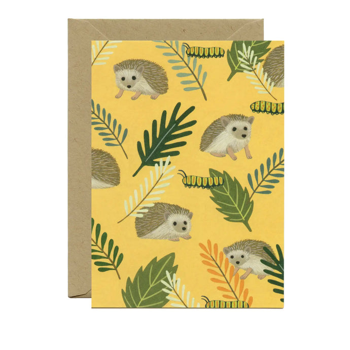 a greeting card with illustration of several hedgehos and variuos green leaves on a golden yellow backdrop with small catterpillars . no text
