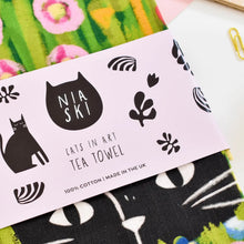 Load image into Gallery viewer, a tea towel with black cat in garden 
