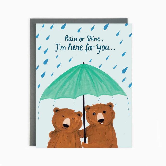 a greeting card with an illustration of two brown bears hugging unt=derneath an open umbrella in the rain, text says rain or shine, I'm here for you