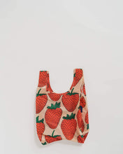 Load image into Gallery viewer, a colour photo of a small baby sized baggu reusable bag with large red strawberries on it , bag is soft peach colour
