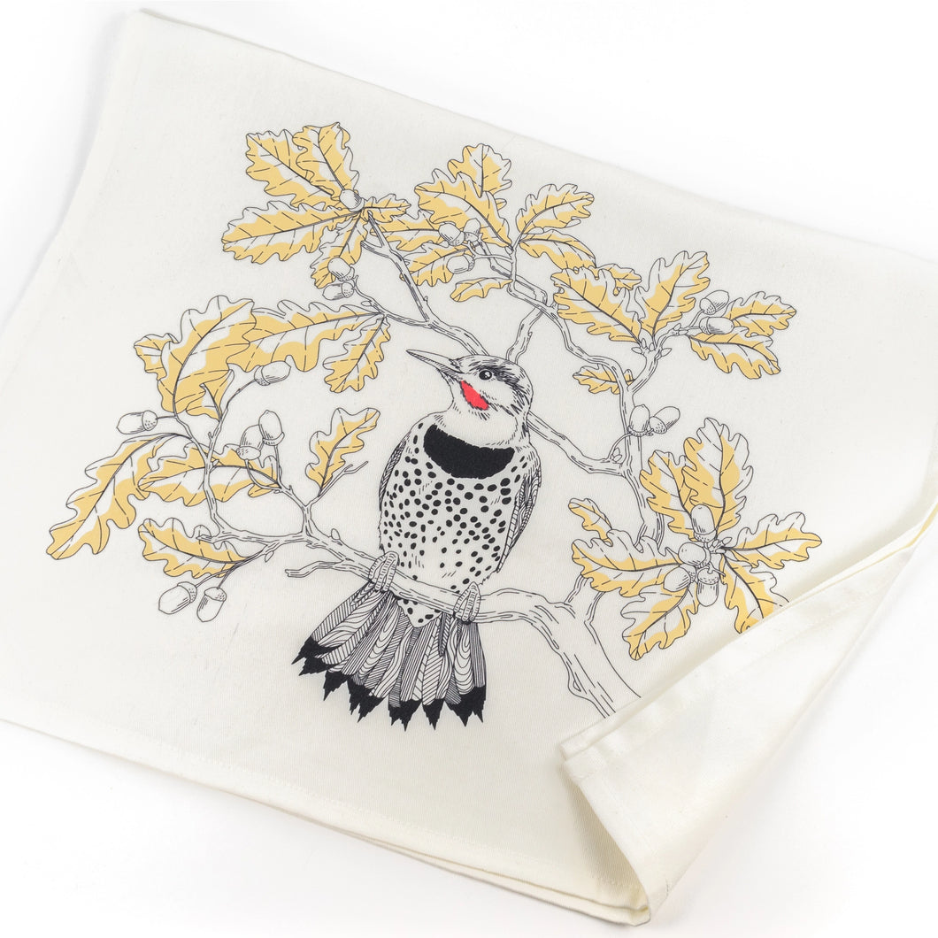 a white tea towel with an illustration of a flicker bird sitting on a branch 