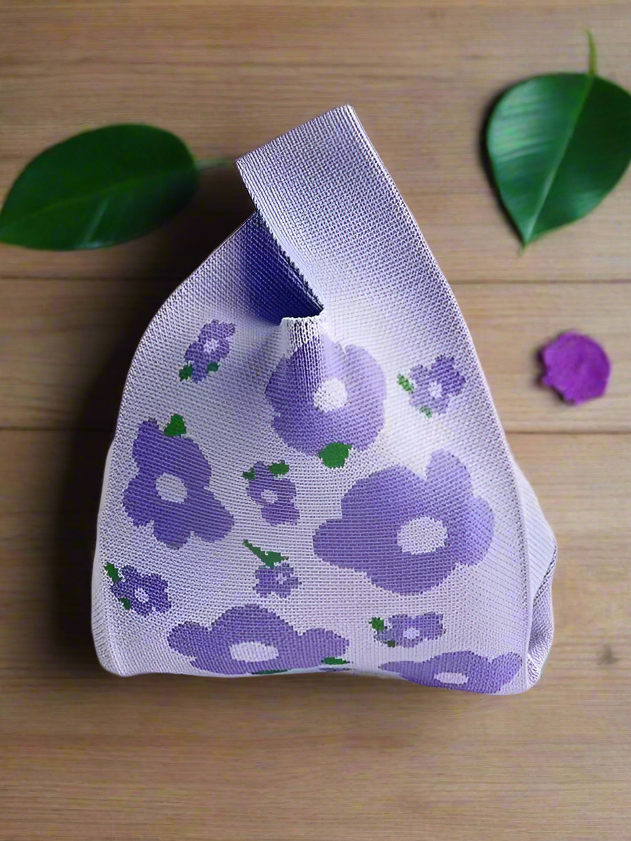 a mauve coloured floral motif on a knitted Japanese style knot bag purse