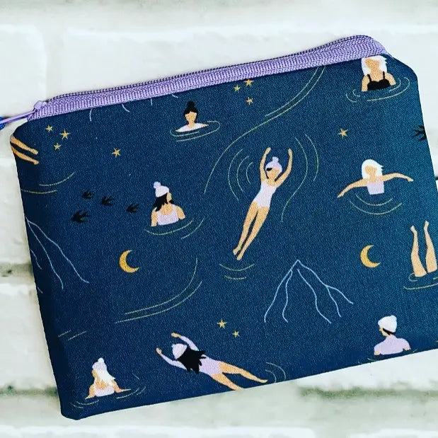 a coin purse pouch with people swimming on it motif in dark blue water