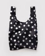 Black reusable bag with white polka dots on a light gray background