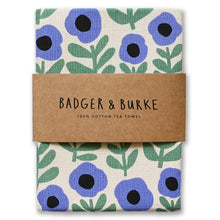 Load image into Gallery viewer, A folded cotton tea towel with a blue and green floral pattern on a cream background, wrapped in a brown kraft paper band that reads 'BADGER &amp; BURKE 100% COTTON TEA TOWEL'.
