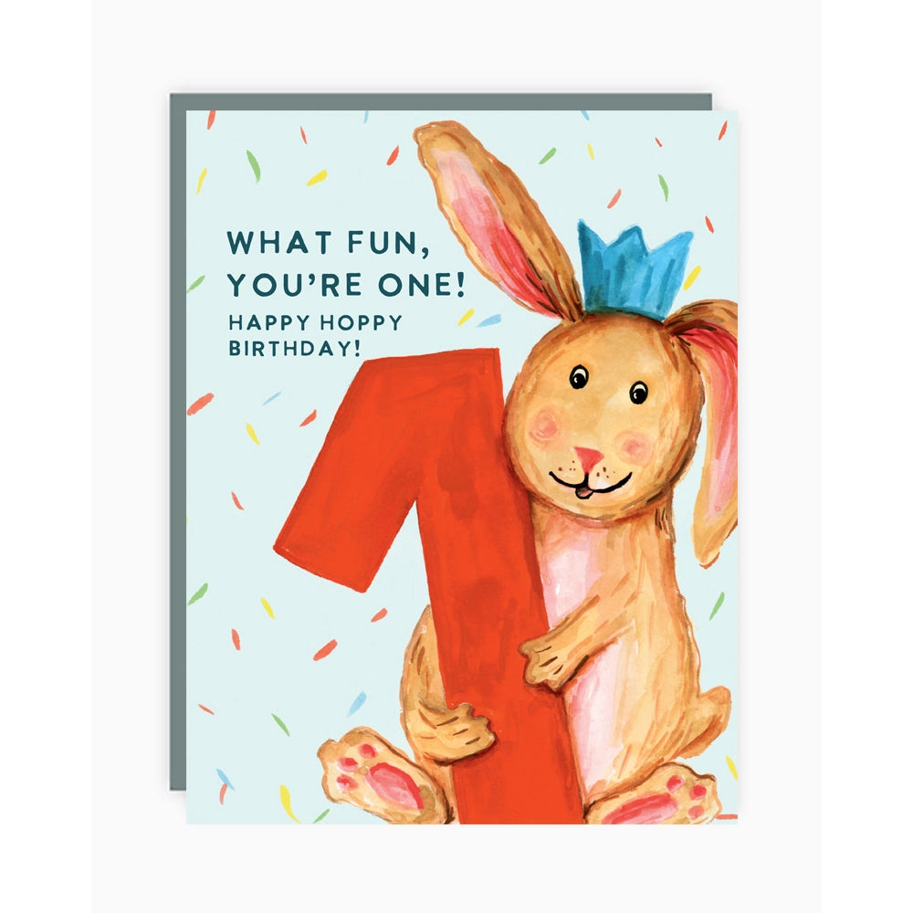 a greeting card with an illustration of a brown bunny holding a big red number one. text what fun you're one happy hoppy birthday 