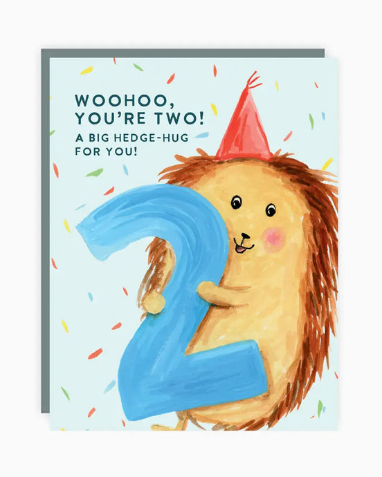 a greeting card with an illustration of a hedgehog holding a big number two text woohoo you're two a big hedge-hug for you