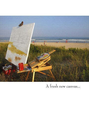 a greeting card with a colour photo of an artists easel with paint brushes and supplies facing a vast beach area . text a fresh new canvas