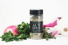 Load image into Gallery viewer, a bottle of Al&#39;s spice with a black label and black top beside what appears to be fresh herbs and a red onion
