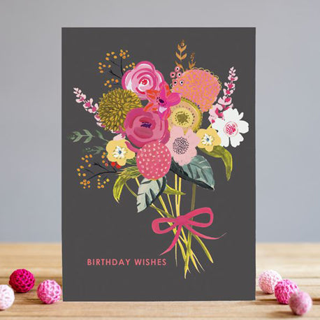 a dark chalkboard coloured card wih a boquet of pink, white and yellow flowers tied with a pink ribbon
