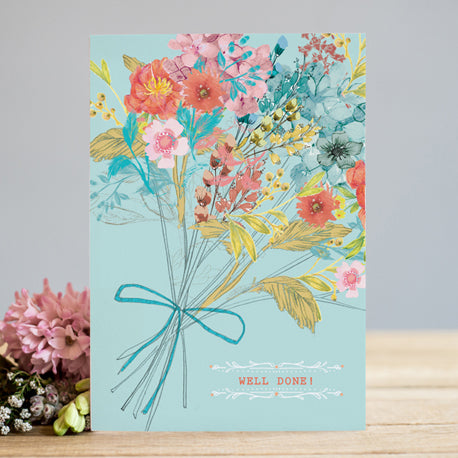an illustration of a bouquet of flowers in peach pink blue and yellow muted tones tied with a small blue ribbon on a robins egg blue back drop with script well down in peach orange colour at bottom