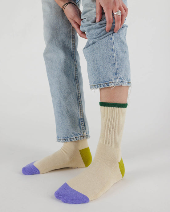 a person wearing the baggu ribbed socks in the ecru mix pattern , ecru colour with purple toe and citron green heal 