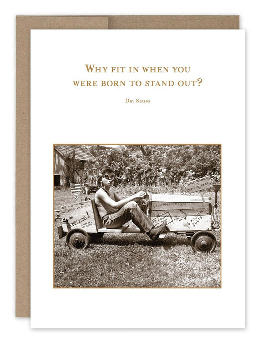 a greeting card with a person driving what appears to be an old go -cart . text. why fit in when you were born to stand out 