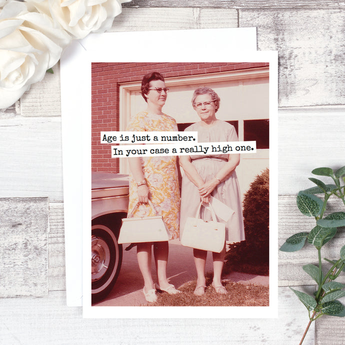a greeting card with mid century vintage photo of 2 elederly ladies in dresses carrying their handbags . text age is jsut a number. In your case a really high one.