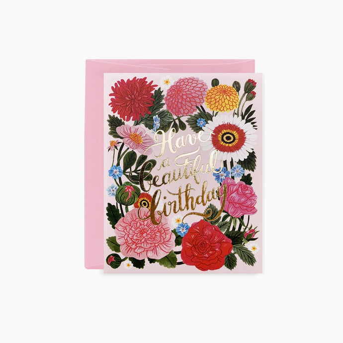 a greeting card with foil illustration of several pink and red flowers with text. have a beautiful birthday , soft pink envelope 