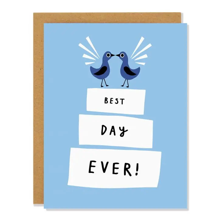 a soft blue greeting card with illustraion of two birds facing each other on top of a 3 tiered wedding cake with text best day ever