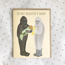 Load image into Gallery viewer, a greeting card with 2 sasquatch one holding a baby one holding a toy text to my besties baby
