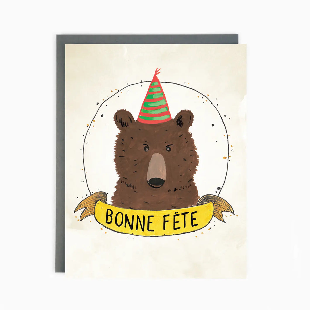 a greeting card with a brown bears face wearing a party hat text bonne fete