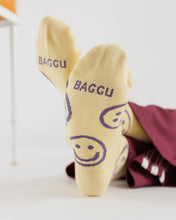 Load image into Gallery viewer, a yellow butter coloured pair of the bottom of baggu socks with purple happy or smiley faces on them
