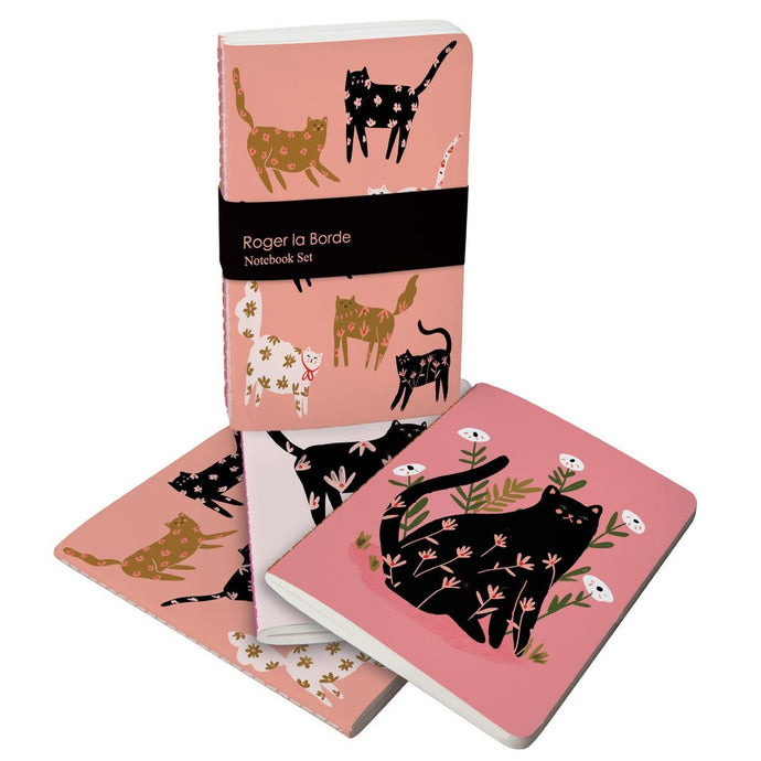 set of 3 roger la borde note books of cat with flowers on their bodies on a muted pink backdrop
