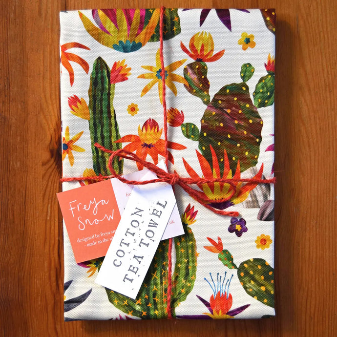 a tea towel with a variety of cactus and desert plants depicted on it 