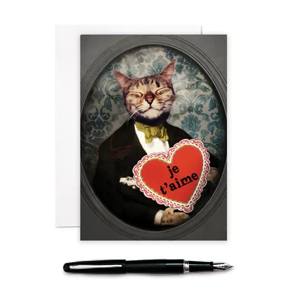 a greeting card with a depiction of a tabby cat dressed in a 19th century outfit holding a red heart with text je t'aime in the heart. 