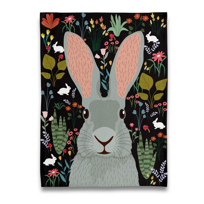 a naked decor tea towel or kitchen towel with a big grey coloured bunny surrounded by blossoms and plants 