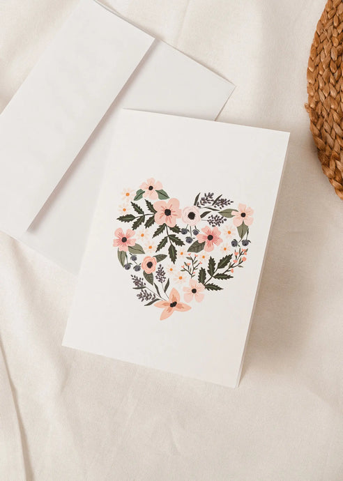 a soft white coloured greeting card with flowers formed into the shape of a heart. no text