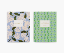 Load image into Gallery viewer, a pair of rifle paper co. notebooks, on white hydrangea the second blue and green swirls 
