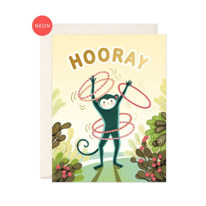 a colourful illustration of a monkey swirling 2 hulla hoops around his waist and on each arm standing by succulent plants on green grass, yellow background says hooray in gold letters at the top 