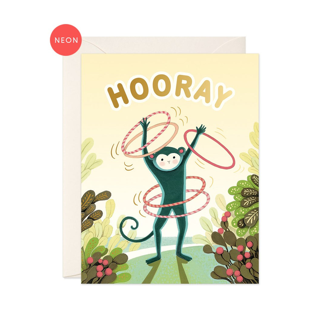 a colourful illustration of a monkey swirling 2 hulla hoops around his waist and on each arm standing by succulent plants on green grass, yellow background says hooray in gold letters at the top 