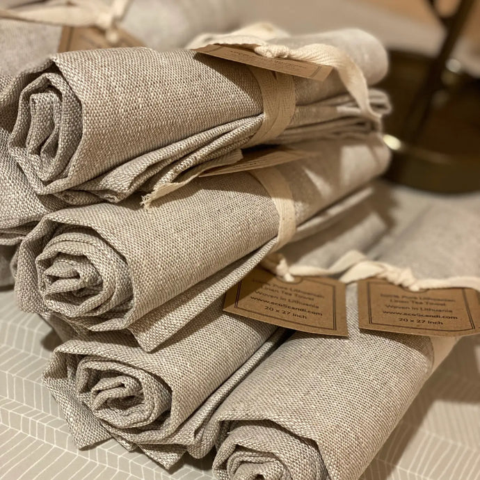 a photo of a stack of linen tea towels in a beige linen colour 
